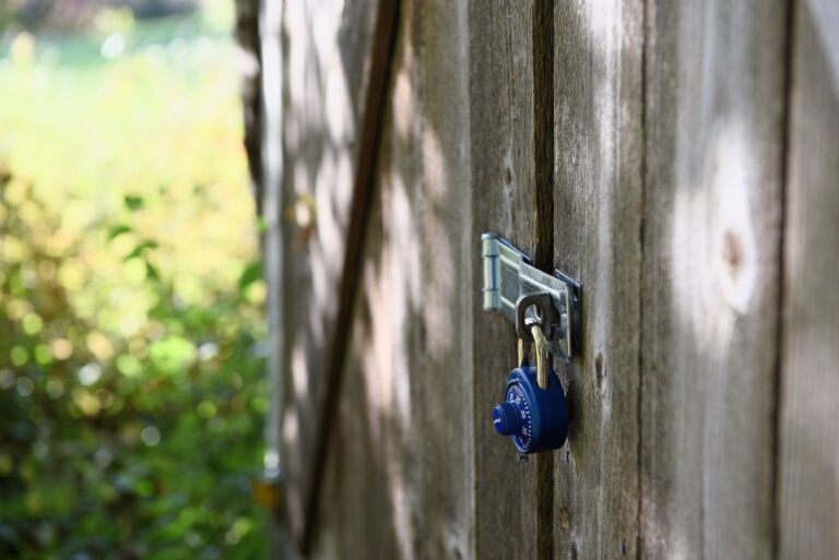 Blauw cijferslot op een houten hek, als symbool voor dataveiligheid